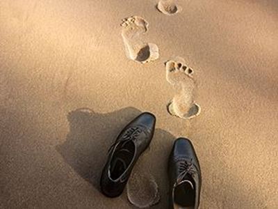 Shoes and footprints in the sand